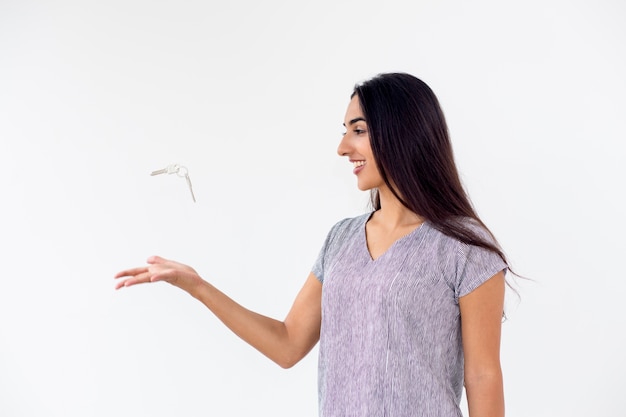 Happy young woman throwing car or house keys