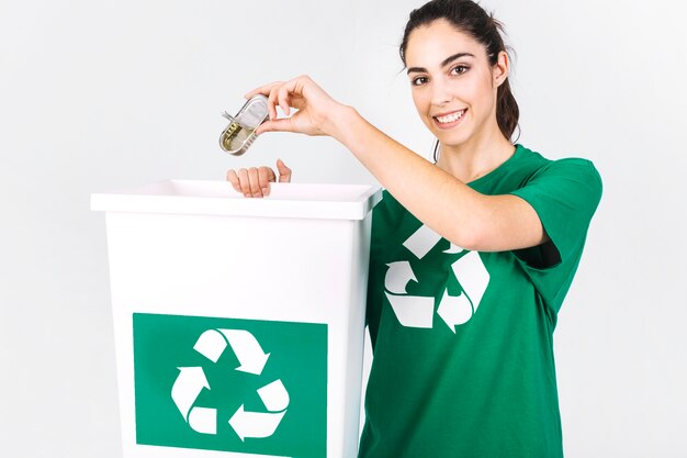 Happy young woman throwing mini tiffin box in recycle dustbin