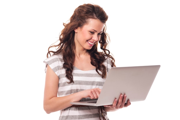 Free photo happy young woman using laptop