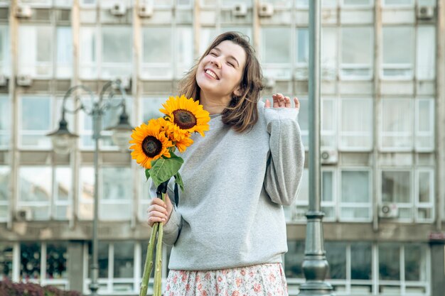 ひまわりの花束を持つ幸せな若い女