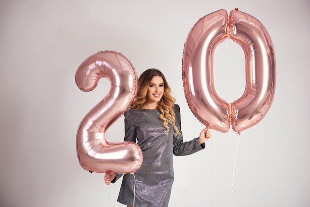 Foto gratuita felice giovane donna con palloncini dorati che celebra il suo compleanno