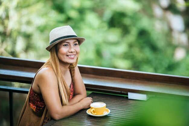 Happy young woman with latte coffee in morning