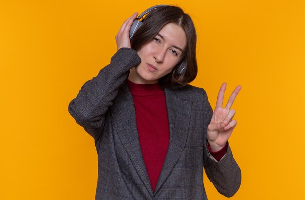 Happy young woman with short hair wearing grey jacket