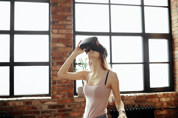 VR 헤드셋과 함께 행복 한 젊은 여자. 집에서 놀기