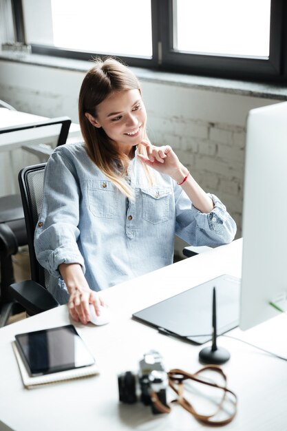 Happy young woman work in office using computer.