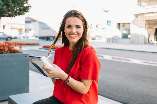 Happy young woman writing note in diary