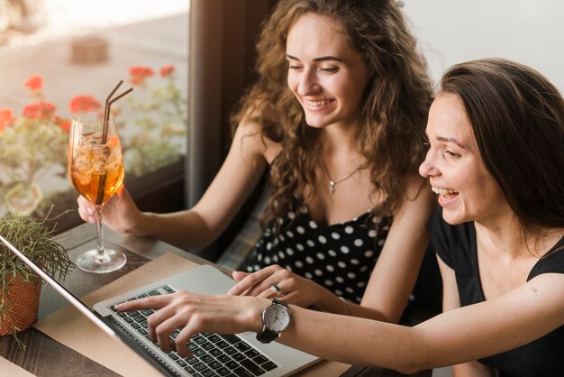 Счастливый молодых женщин, глядя на ноутбук