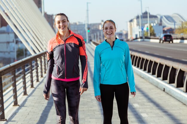 Happy young women in sportswear posing