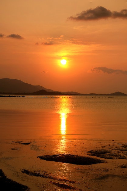 港の雲がオレンジ色の夕暮れを見ます