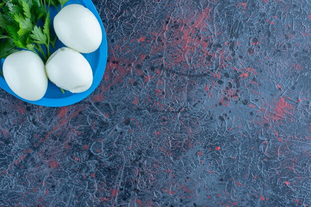 Hard boiled egg with herbs on marble background. 