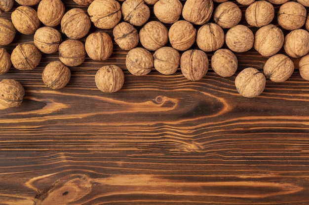 Free photo hard shell walnuts on wooden surface with copy space