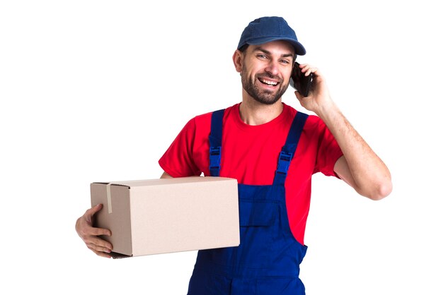 Hard worker courier man holding a box and talking on phone
