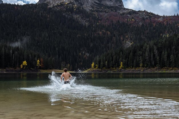 찬물에서 경화 몬테네그로 Durmitor 공원의 가을 호수에서 목욕하는 남자