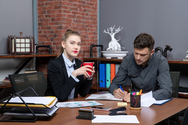 Hardworking and serious professional workers discussing one issue in the documents in the office