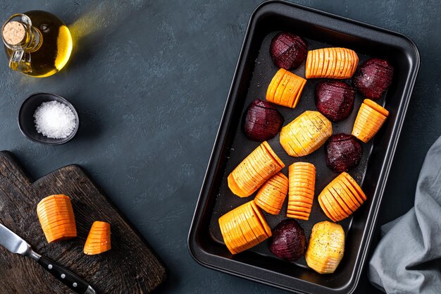 Hasselbeckstyle chopped root vegetables on a black tray