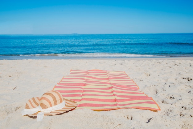 Бесплатное фото Шляпа и одеяло на пляже