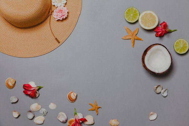 Hat, citrus fruits, coconut, shells and flowers