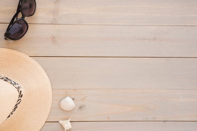 Hat near seashells and sunglasses