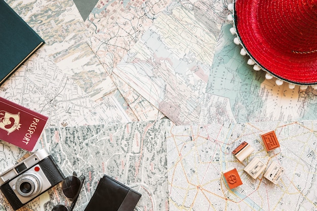 Hat with camera and passport on map