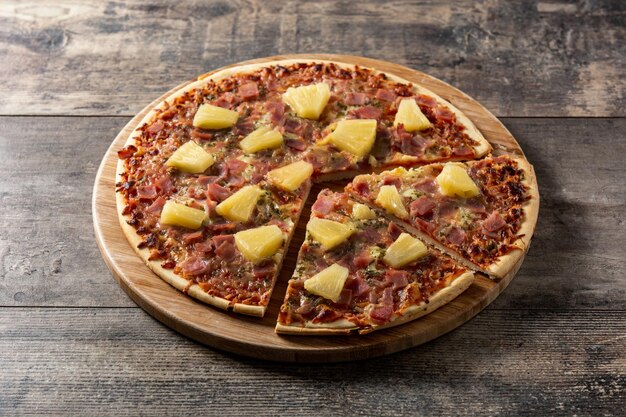 hawaiian pizza with pineappleham and cheese on wooden table