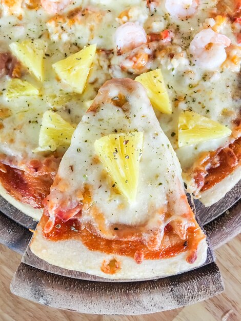 Hawaiian pizza on wood tray