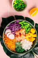 Free photo hawaiian poke bowl with salmon in a bowl with seaweed sesame seeds and cabbage top view flat lay vertical