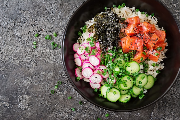 쌀, 무, 오이, 토마토, 참깨 및 해초를 넣은 하와이 연어 생선 찌개. 부처님 그릇. 다이어트 음식. 평면도. 평평하다.