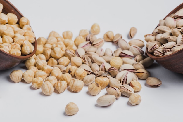 Hazelnuts and pistachios spilled from bowl