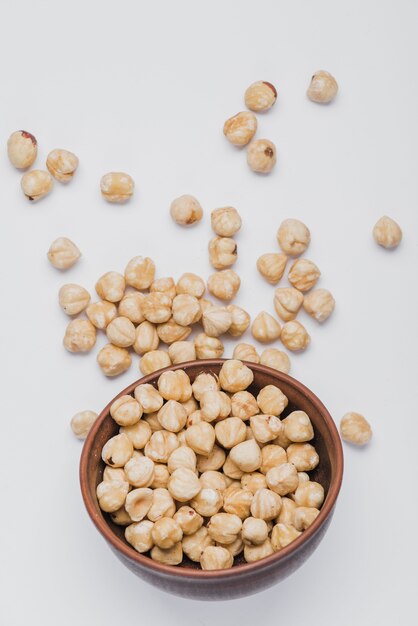 Hazelnuts spilled near bowl