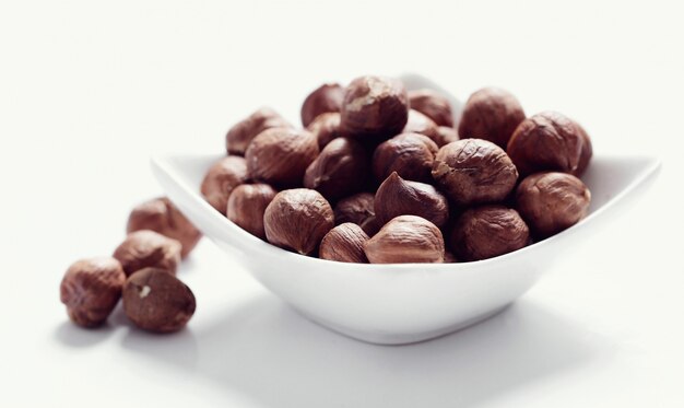 Hazelnuts on white bowl