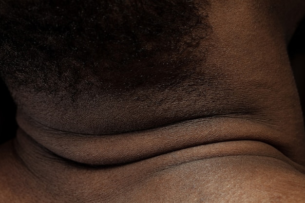 Head, neck. Detailed texture of human skin. Close up shot of young african-american male body. Skincare, bodycare, healthcare, hygiene and medicine concept. Looks beauty and well-kept. Dermatology.
