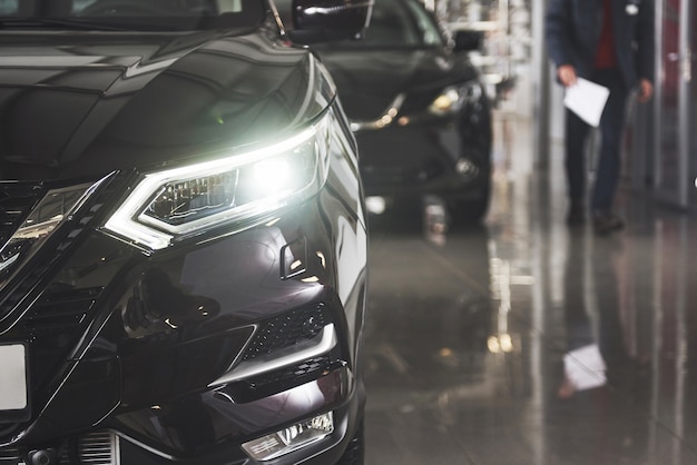 The headlights and the hood of a black luxury car.