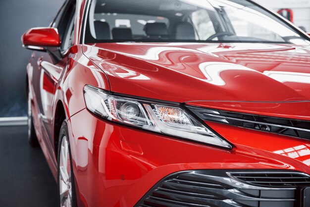 Headlights of the new red car, in the car dealership.