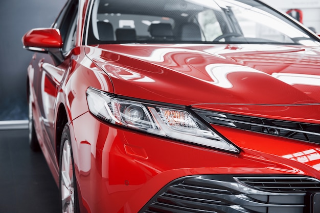 Headlights of the new red car, in the car dealership.