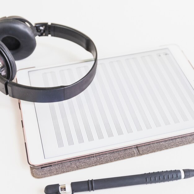 스타일러스 펜으로 화면에 음표가있는 그래픽 디지털 태블릿을 통한 헤드폰