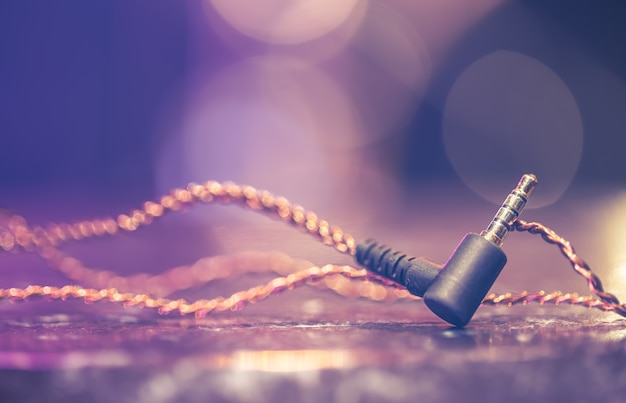 Headphone jack on blurred background with stage lighting.