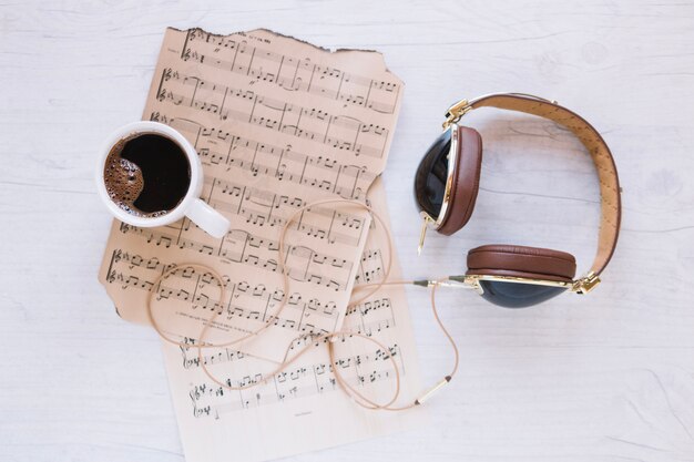 Headphones and coffee near sheet music