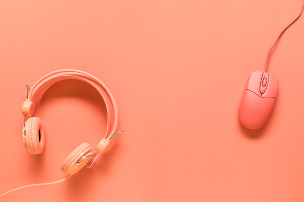 Headphones and mouse on orange background