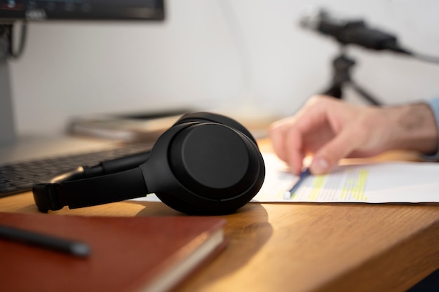 Headphones for podcasting sitting on the table next to man