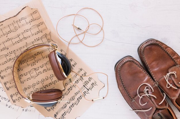 Headphones and shoes near sheet music