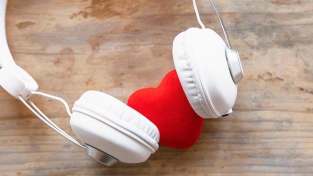 Headphones with red heart on wooden table