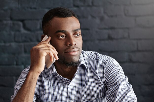 Headshot of attractive young dark-skinned male in formal wear having serious and confident look