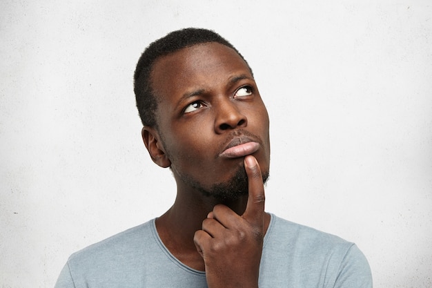 Free photo headshot of attractive young dark-skinned man dressed casually looking upwards