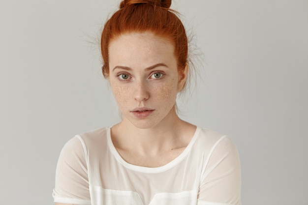 Free photo headshot of attractive young woman of extraordinary appearance looking with shy subtle smile dressed in white blouse.