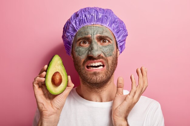 Headshot of displeased male doing his beauty routine