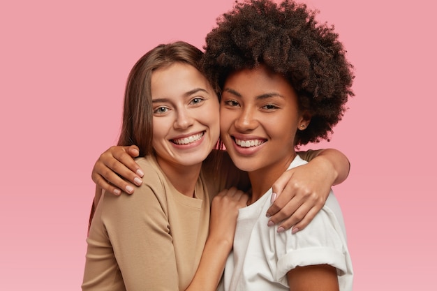 Free photo headshot of good looking women with positive expressions, cuddle each other