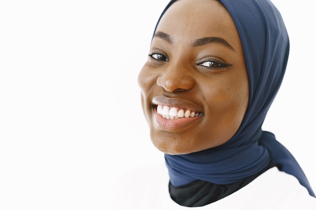 Headshot of lovely satisfied religious muslim woman with gentle smile, dark healthy skin, wears scarf on head. isolated over white background. Premium Photo