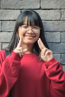 かわいいアジアの女子高生は親指ジェスチャーを行い 青に手を開きます 無料の写真 かわいいアジアの女子高生は親指ジェスチャーを行い 青に手を開きます 無料の写真