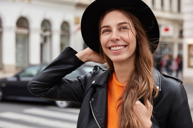 Headshot of optimistic European woman feels free and delighted