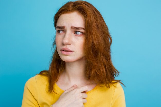 얼굴 만 카메라를보고 웃 고 주 근 깨와 행복 생강 빨간 머리 여자의 초상화. 파스텔 블루 배경입니다. 공간을 복사하십시오.